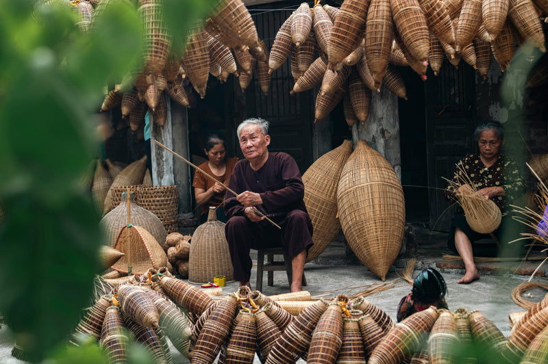 Traditional Vietnamese craftsmen making bamboo fish traps in Vietnam